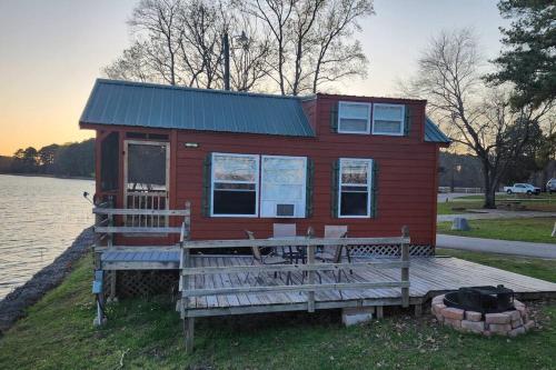 a red house with a dock and a table and chairs at Wheeler Lake Riverbend Haven 2 in Stilwell