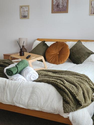 a bed with a blanket and pillows on it at CHERRYTREE COTTAGE @ LOMOND in Hornsea