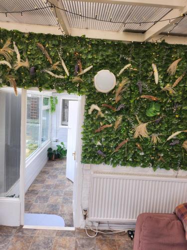 a wall covered in ivy in a living room at CHERRYTREE COTTAGE @ LOMOND in Hornsea