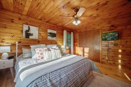 1 dormitorio con 1 cama en una cabaña de madera en Sunset Peak - Treehouse - Kid Zone -FirePit-HotTub, en Ellijay