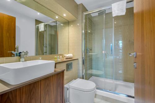 een badkamer met een douche, een toilet en een wastafel bij Talisman & Duckman Tower at Canary Wharf by MySquare in Londen
