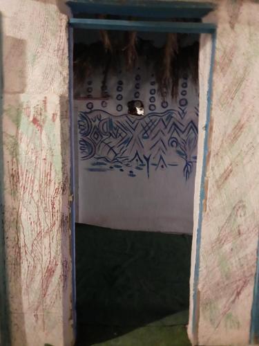 a door to a room with a sign on the wall at Perry’s Island Camp Al Mezina in Nuweiba