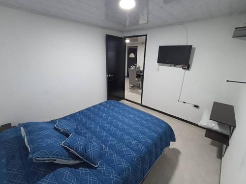 um quarto com uma cama azul e um espelho em Departamento amoblado en Kennedy central em Bogotá
