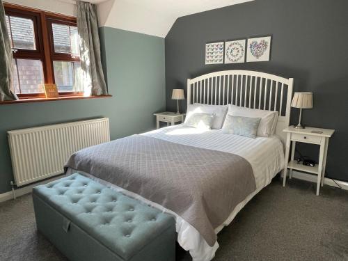 a bedroom with a large bed and a blue ottoman at Comfortable and spacious apartment with parking in Canterbury