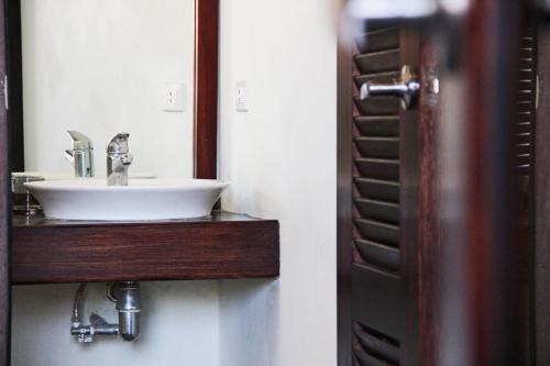 a bathroom with a sink and a mirror at Hotel and Coffe Azul in León