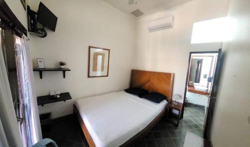 a small bedroom with a bed and a mirror at Hotel and Coffe Azul in León