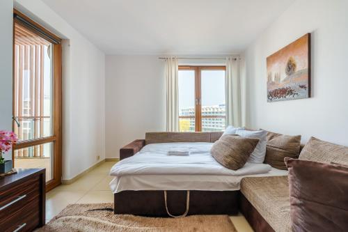 a living room with a couch and a bed at Olympic Park Apartment with the Sea View in Kołobrzeg