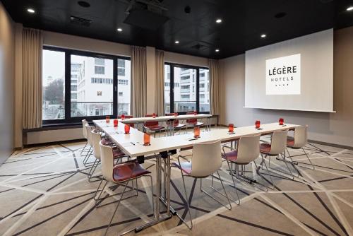 a conference room with a long table and chairs at LÉGÈRE HOTEL Bielefeld in Bielefeld