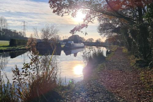 une rivière avec le soleil réfléchissant dans l'eau dans l'établissement Shrigley cottage, quirky & quiet, à Macclesfield