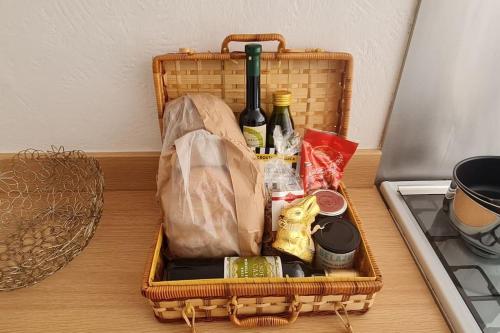 a basket filled with food and bottles of wine on a counter at Shrigley cottage, quirky & quiet in Macclesfield
