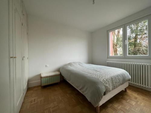 une chambre blanche avec un lit et une fenêtre dans l'établissement Appartement Chaleureux Portes de Paris, à Aubervilliers