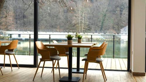 a table and chairs in a room with a large window at Waterside SPA Hotel in Ognyanovo