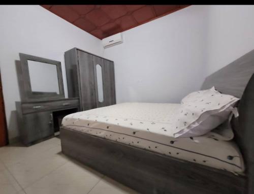 Bett in einem Zimmer mit einem Spiegel und einem Bett sidx sidx sidx sidx in der Unterkunft Résidence privée in Conakry