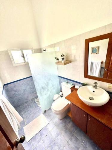 a bathroom with a toilet and a sink and a mirror at Amplia Villa en Metro Country Club in La Puntica de Juan Dolio