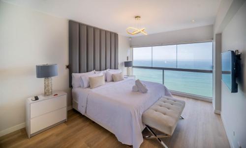 a bedroom with a large bed and a large window at Luxury Ocean View Penthouse with Pool in Miraflores in Lima