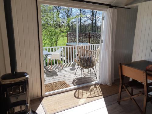 a screened in porch with a chair and a table at Pipowagen Warm Welkom in Wezep