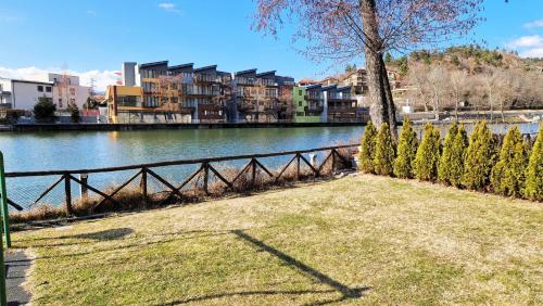 a park next to a river with trees and buildings at Waterside SPA Hotel in Ognyanovo