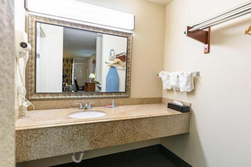 a bathroom with a sink and a large mirror at Eco-Inn Suites Baytown in Baytown