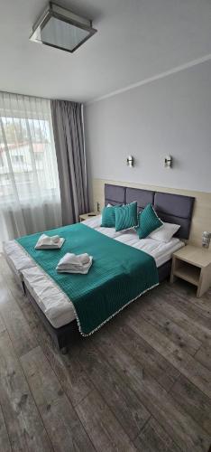 a bedroom with two beds with blue and green pillows at 28 Dominikana in Sianozety