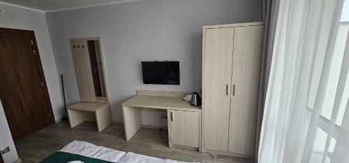 a room with a desk with a television and a cabinet at 28 Dominikana in Sianozety