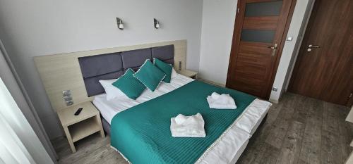 28 Dominikana في سيانوزيتي: غرفة نوم بسرير اخضر عليها منشفتين
