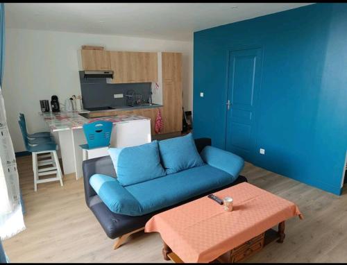 un salon avec un canapé bleu et une table dans l'établissement appartement, à Laval