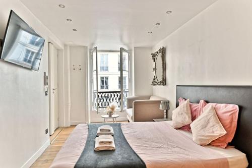 une chambre avec un grand lit avec des oreillers roses dans l'établissement Agréable Appartement Proche Galerie Lafayette - II, à Paris