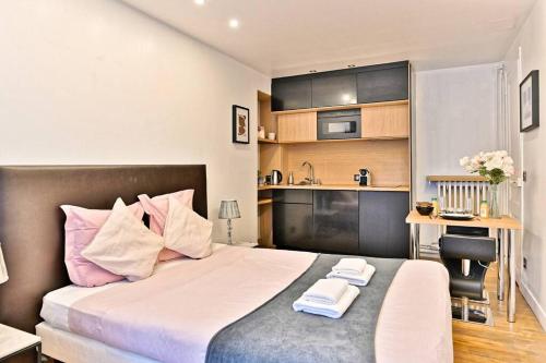 Cet appartement comprend une chambre avec un lit, un bureau et une cuisine. dans l'établissement Agréable Appartement Proche Galerie Lafayette - II, à Paris