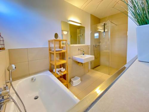 een badkamer met een bad en een wastafel bij Ferienwohnung Koje 2 in Ostseebad Karlshagen