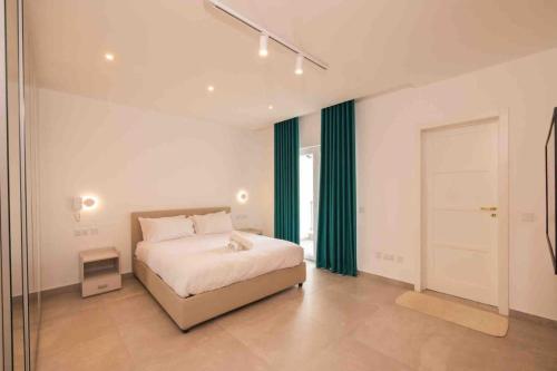 een slaapkamer met een bed met groene gordijnen en een deur bij Swieqi 3 bedroom apartment (4) in Is-Swieqi