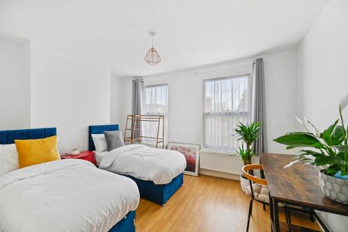 sypialnia z 2 łóżkami oraz stołem i stołem w obiekcie Cosy Urban Oasis 2 Bedroom Flat in Tottenham ( Sleeps 5 People ) w Londynie