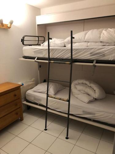 Cette chambre comprend 3 lits superposés, une table et un bureau. dans l'établissement Appt 8 pers / garage / terrasse / vue mer, à Sète