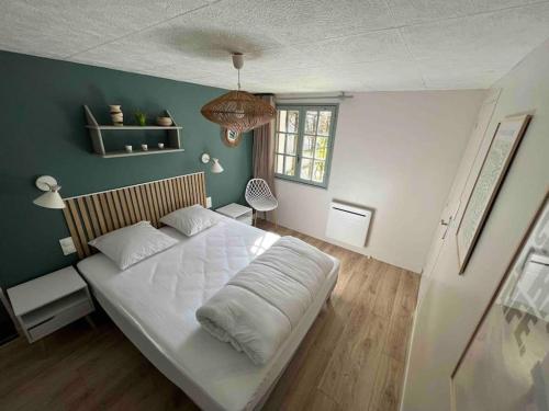 une chambre avec un lit blanc et un mur vert dans l'établissement Maisonette Ti’calypso T2 - proche plage, à Saint-Nazaire