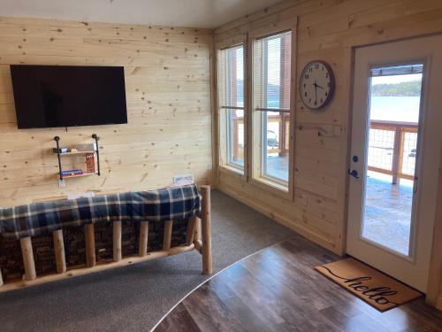 a living room with a tv on a wooden wall at Keweenaw Waters Resort in Houghton
