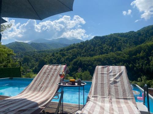 una piscina con due sedie e un tavolo con vista sulle montagne di Aphrodite Hills Apartments-Stara Planina a Crni Vrh