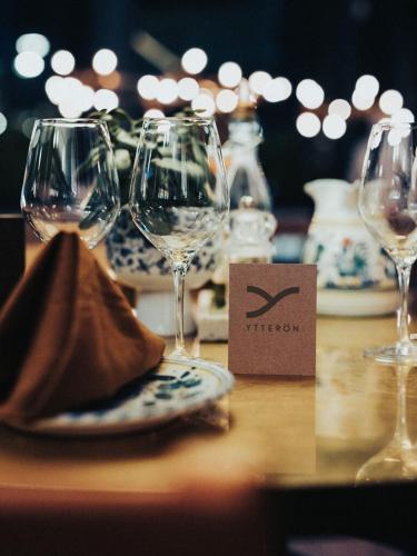 a table with wine glasses and a plate on it at Ytterön skärgårdshotell in Torhamn