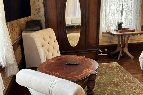 a living room with a table and a chair and a mirror at The Orth House Inn by Remotion in Jacksonville