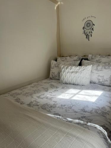 - un lit avec une couette et des oreillers blancs dans l'établissement MISCANTHUS, à Honfleur