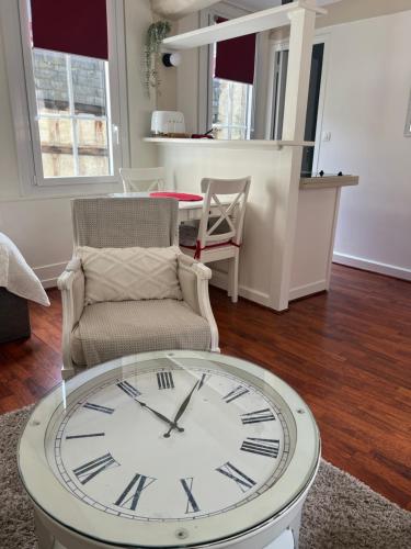 un salon avec une horloge et une chaise dans l'établissement MISCANTHUS, à Honfleur