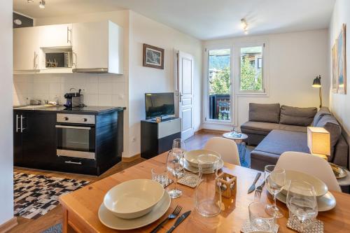 une cuisine et un salon avec une table et des chaises dans l'établissement Le Balcon du Brevent - Central - Vue montagne, à Chamonix-Mont-Blanc