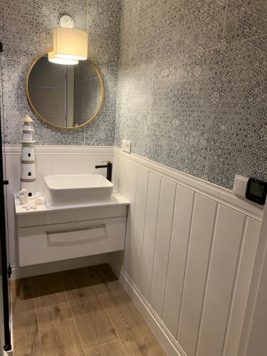a bathroom with a sink and a mirror at Apartamenty Piaskowe z balkonem in Rowy