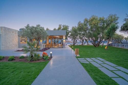 a walkway in front of a building with a yard at Regia Mare Beach Hotel & Spa Bodrum in Ortakent