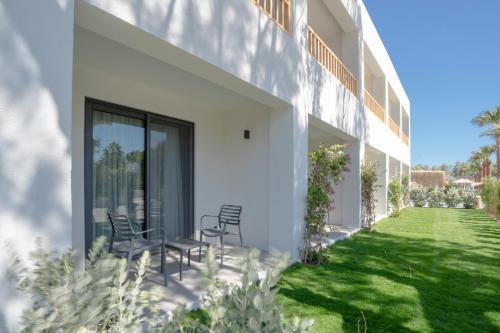 a patio with chairs and a table on the side of a building at Regia Mare Beach Hotel & Spa Bodrum in Ortakent