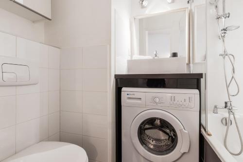 une salle de bain avec machine à laver et toilettes dans l'établissement Le Balcon du Brevent - Central - Vue montagne, à Chamonix-Mont-Blanc