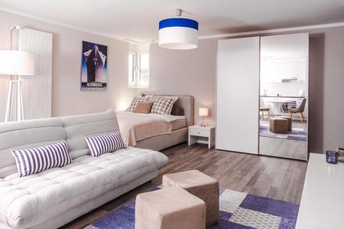 ein Wohnzimmer mit einem Sofa und einem Bett in der Unterkunft RELOC Serviced Apartments Zurich-Oerlikon in Zürich