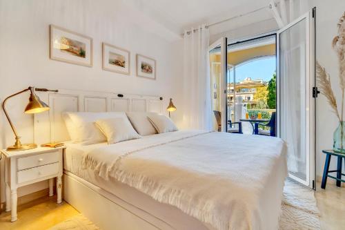 a white bedroom with a bed and a balcony at Casita Bonita - with private garden near beach in Jávea in Jávea