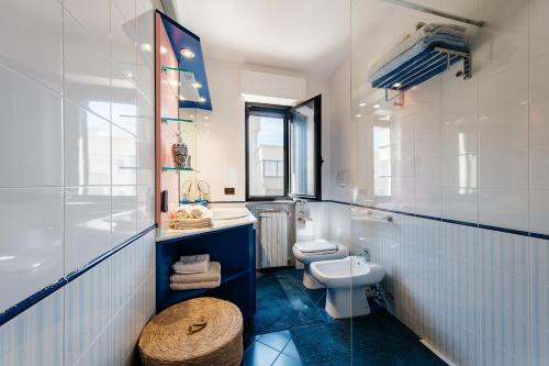 een blauwe en witte badkamer met een toilet en een wastafel bij Casa Nilla in Monopoli