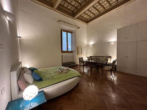 a bedroom with a large bed and a dining room at Residenza Storica in Villa Palazzo Bruciato in Florence