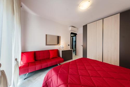 een slaapkamer met een rood bed en een rode bank bij Casa Nilla in Monopoli