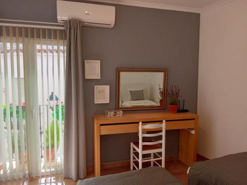 Zimmer mit einem Schreibtisch, einem Spiegel und einem Fenster in der Unterkunft Casa Elena in Orba